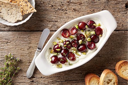 snack - Goats cheese with sauteed cherries, pistachios and fresh thyme.  Served with bread and flax seed crackers Stock Photo - Premium Royalty-Free, Code: 614-07735616