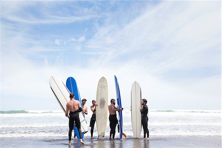 simsearch:614-07768195,k - Group of male and female surfer friends standing on beach with surf boards Stock Photo - Premium Royalty-Free, Code: 614-07767982