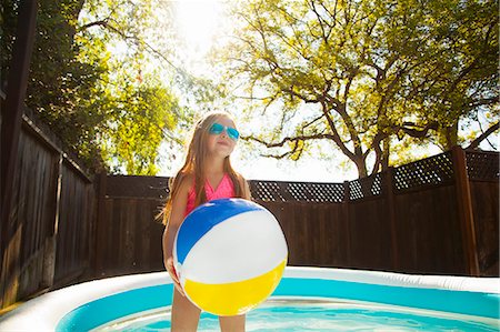 simsearch:614-07768086,k - Girl holding beachball in garden paddling pool Stock Photo - Premium Royalty-Free, Code: 614-07768075