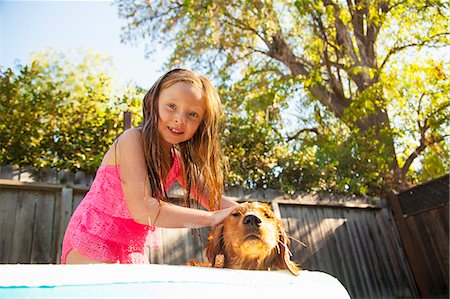 person and dog and play and happy - Portrait of girl petting dog in garden paddling pool Stock Photo - Premium Royalty-Free, Code: 614-07768070