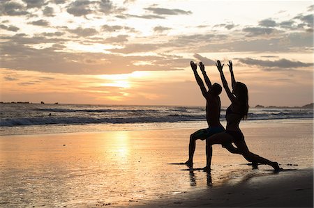 stretching - Couple doing stretching exercises on beach at sunset, Nosara, Guanacaste, Costa Rica Stockbilder - Premium RF Lizenzfrei, Bildnummer: 614-07768217