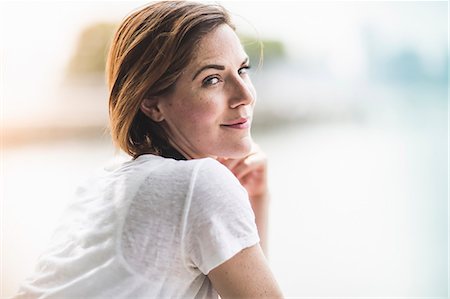 summer - Portrait of mid adult woman looking over her shoulder Stock Photo - Premium Royalty-Free, Code: 614-07768226