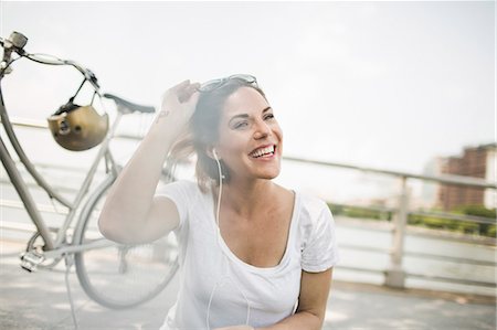 einzelperson - Portrait of smiling mid adult woman cyclist listening to earphones Stockbilder - Premium RF Lizenzfrei, Bildnummer: 614-07768237
