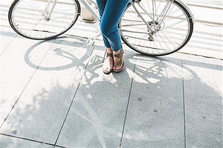 Legs of mid adult woman cyclist and bicycle Stock Photo - Premium Royalty-Free, Code: 614-07768233