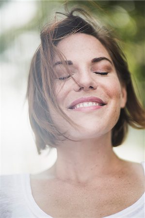 Close up portrait of smiling mid adult woman with eyes closed Photographie de stock - Premium Libres de Droits, Code: 614-07768240