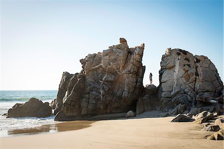 Young woman standing on rocks on beach Photographie de stock - Premium Libres de Droits, Code: 614-07768257