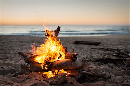 Bonfire burning on beach Stock Photo - Premium Royalty-Free, Code: 614-07768259