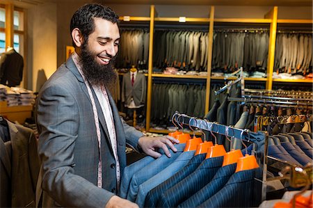 Tailor looking at business jacket display in men's clothes shop Stock Photo - Premium Royalty-Free, Code: 614-07768271