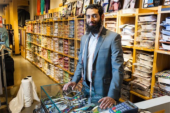 Portrait of tailor behind counter in men's clothes shop Stock Photo - Premium Royalty-Free, Image code: 614-07768272