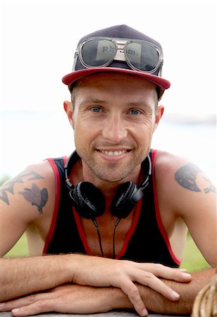 portrait tattoos for men - Portrait of smiling mid adult man wearing baseball cap at coast Foto de stock - Sin royalties Premium, Código: 614-07768293