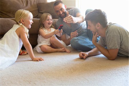 Male couple and two daughters playing on sitting room floor Stock Photo - Premium Royalty-Free, Code: 614-07805892