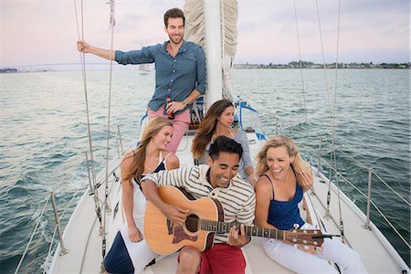 Friends on sailing boat, man playing guitar Stock Photo - Premium Royalty-Free, Code: 614-07805989