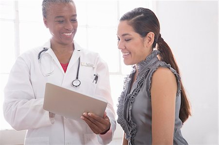 patient consulting doctor - Female doctor showing patient digital tablet Stock Photo - Premium Royalty-Free, Code: 614-07806079