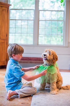 Young boy playing dress up with pet dog Foto de stock - Sin royalties Premium, Código: 614-07806156