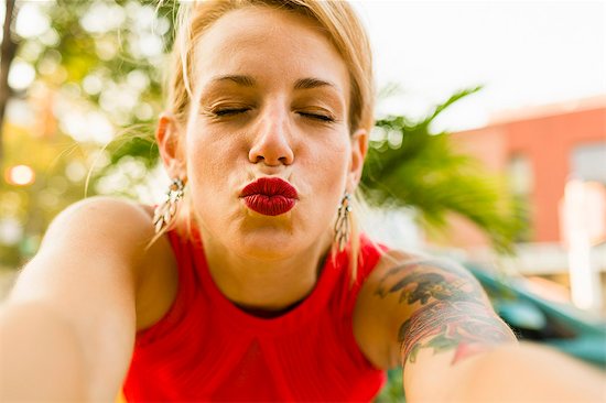 Portrait of young woman in red posing for selfie Photographie de stock - Premium Libres de Droits, Le code de l’image : 614-07806192