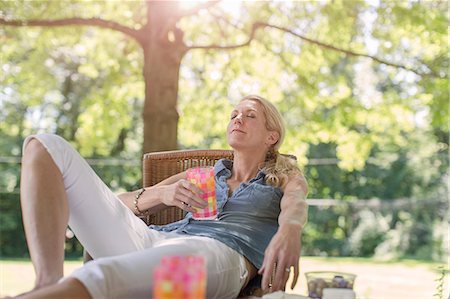 Mature woman relaxing in garden with drink Foto de stock - Sin royalties Premium, Código: 614-07806340