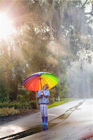 simsearch:614-07806399,k - Boy carrying umbrella and looking up on street Foto de stock - Sin royalties Premium, Código: 614-07806394