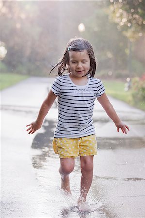 simsearch:614-07805747,k - Barefoot girl running through puddles on rainy street Foto de stock - Sin royalties Premium, Código: 614-07806396