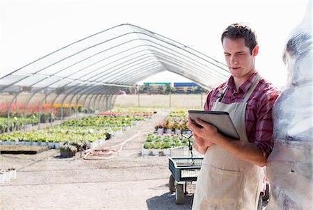 environmental issues for computers - Young male horticulturalist using digital tablet at plant nursery Stock Photo - Premium Royalty-Free, Code: 614-07806415