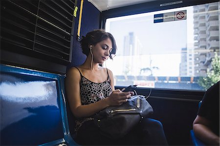 Young woman commuting on bus listening to music on smartphone, New York, US Stockbilder - Premium RF Lizenzfrei, Bildnummer: 614-07806450