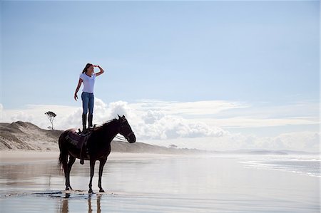 standing on the beach - Horse rider standing on horse, Pakiri Beach, Auckland, New Zealand Stock Photo - Premium Royalty-Free, Code: 614-07911665