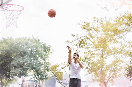 puntaje - Young male basketball player throwing ball towards basketball net Foto de stock - Sin royalties Premium, Código: 614-07911673