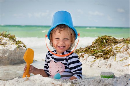 simsearch:6108-08663086,k - Baby girl with bucket over head on beach, Anna Maria Island, Florida, USA Foto de stock - Royalty Free Premium, Número: 614-07911848