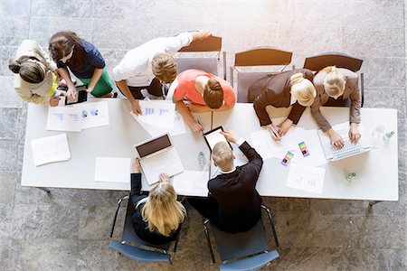simsearch:614-07911910,k - Overhead view of business team brainstorming at desk in office Photographie de stock - Premium Libres de Droits, Code: 614-07911914