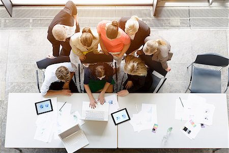 female and meeting and thirties - Overhead view of huddled business team meeting at desk in office Stock Photo - Premium Royalty-Free, Code: 614-07911918