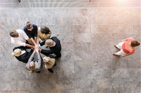 simsearch:649-08084743,k - Overhead view of business team in circle with hands together Photographie de stock - Premium Libres de Droits, Code: 614-07911910