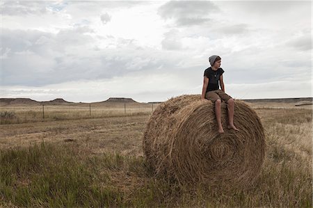 dakota del sur - Teenage boy sitting on haystack in field, South Dakota, USA Foto de stock - Sin royalties Premium, Código: 614-07912004