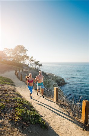 simsearch:614-08392515,k - Mid adult man and young woman jogging on path by sea Stock Photo - Premium Royalty-Free, Code: 614-07912032