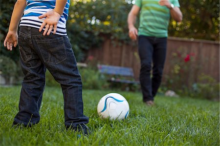 father and son play football - Father and son playing football in garden Stock Photo - Premium Royalty-Free, Code: 614-08000138