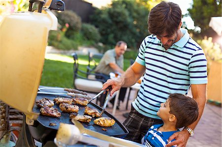 dad grilling - Father and son at barbecue grill in garden Stock Photo - Premium Royalty-Free, Code: 614-08000154