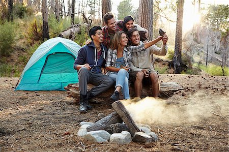 Four young adult friends taking smartphone selfie by campfire in forest, Los Angeles, California, USA Fotografie stock - Premium Royalty-Free, Codice: 614-08000204