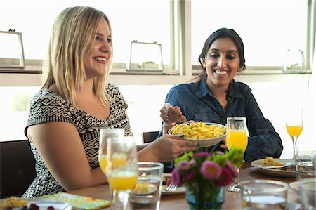 simsearch:614-08000236,k - Group of friends having meal at table, young woman passing plate to friend Stock Photo - Premium Royalty-Free, Code: 614-08000241