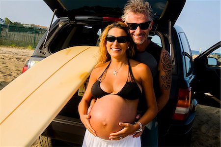 embrace sport - Portrait of mature male surfer embracing pregnant wife at beach Stock Photo - Premium Royalty-Free, Code: 614-08000264