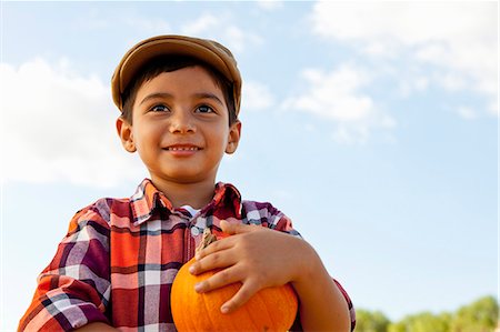 pumpkin farm - Portrait of boy holding pumpkin in pumpkin field Stock Photo - Premium Royalty-Free, Code: 614-08000394