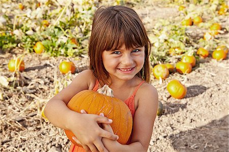 fall, season - Portrait of girl holding pumpkin in pumpkin field Stock Photo - Premium Royalty-Free, Code: 614-08000395