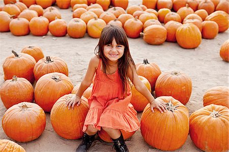 simsearch:614-03818705,k - Portrait of girl sitting on pumpkin in farmyard Fotografie stock - Premium Royalty-Free, Codice: 614-08000399