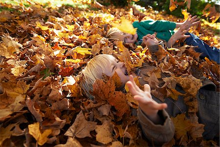 Two boys playing in pile of leaves Photographie de stock - Premium Libres de Droits, Code: 614-08030436