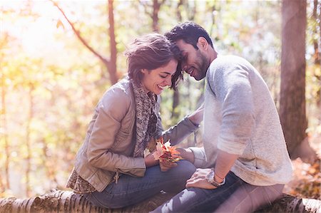 fall - Couple sitting on fallen tree with autumn leafs in forest Stock Photo - Premium Royalty-Free, Code: 614-08030457