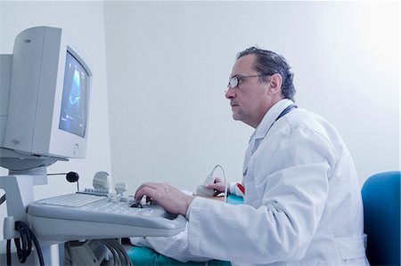 physician studying - Sonographer looking at ultrasound scan on computer screen whilst scanning Stock Photo - Premium Royalty-Free, Code: 614-08030609