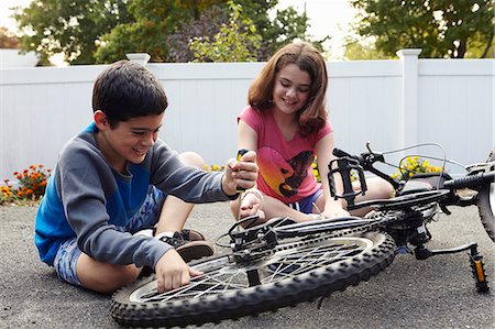 photos of boys short pants - Brother and sister repairing bicycle on driveway Stock Photo - Premium Royalty-Free, Code: 614-08030630