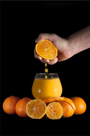 Hand squeezing oranges into drinking glass Stockbilder - Premium RF Lizenzfrei, Bildnummer: 614-08030644