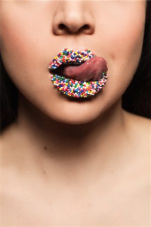 simsearch:614-06897685,k - Mid adult woman licking sprinkles on lips Photographie de stock - Premium Libres de Droits, Code: 614-08030705