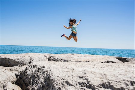 Young woman jumping over rocks, Scarborough Bluffs, Toronto, Ontario, Canada Photographie de stock - Premium Libres de Droits, Code: 614-08030762