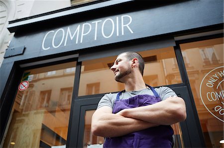 Portrait of restaurant owner, outside his business, low angle view Stock Photo - Premium Royalty-Free, Code: 614-08030798