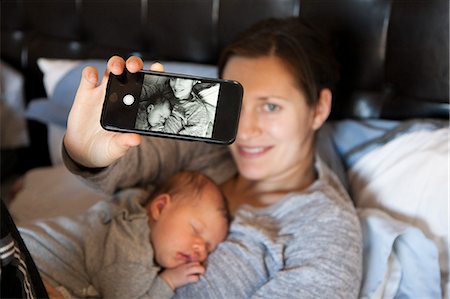 simsearch:614-08875430,k - Baby girl sleeping on mother's chest, while mother takes self portrait of them both, using smartphone Fotografie stock - Premium Royalty-Free, Codice: 614-08030791