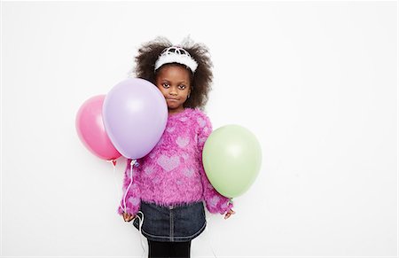 Girl wearing tiara and holding balloons Stock Photo - Premium Royalty-Free, Code: 614-08030857